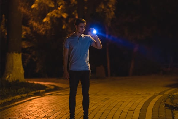 Image of planned cloths security guard with a flashlight.