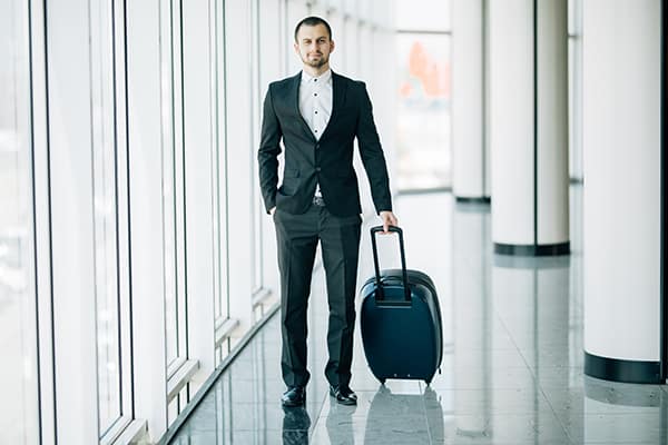 Security minded Customer Services - Man walking holding suitcase