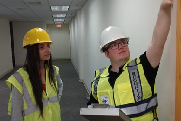 Image of security guard supervisor talking to a security guard on duty.