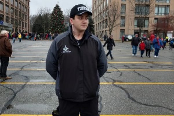 Image of an unarmed uniformed security guard standing in parking lot.